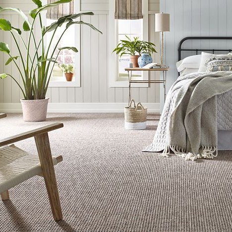 white bed and white chair on a beige carpet from Perge Carpet & Floors in Wheaton, MD